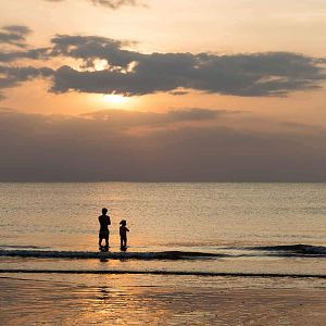 Father and daughter watching the sunset