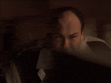 a close up of a man 's face with a slight smirk on his face .